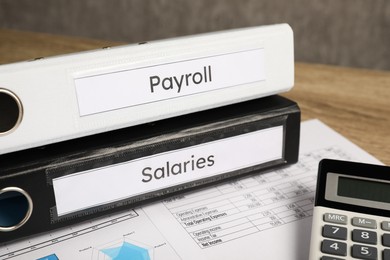 Photo of Payroll. Calculator and papers on table, closeup