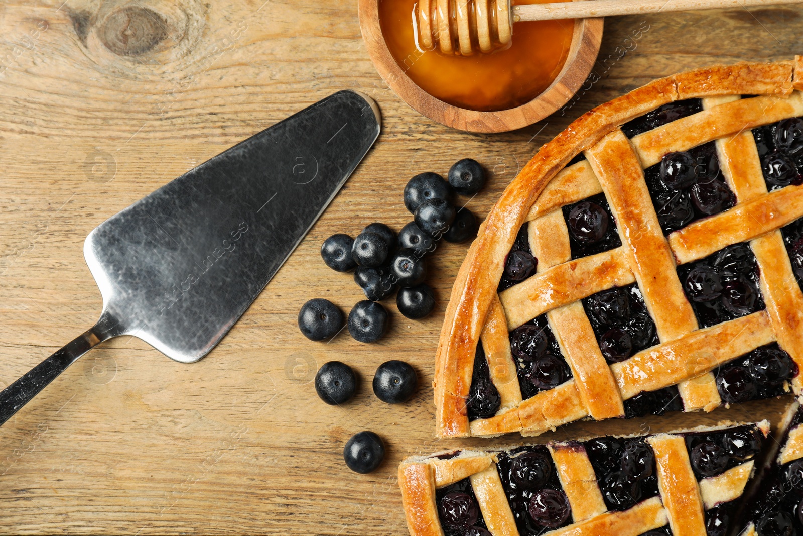 Photo of Tasty homemade pie with blueberries served on wooden table, flat lay