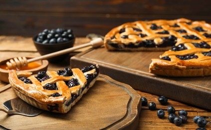 Photo of Tasty homemade pie with blueberries served on wooden table