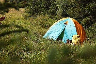 Photo of Tent on green grass in mountains, space for text