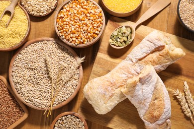 Photo of Different types of cereals and seeds on wooden table, flat lay