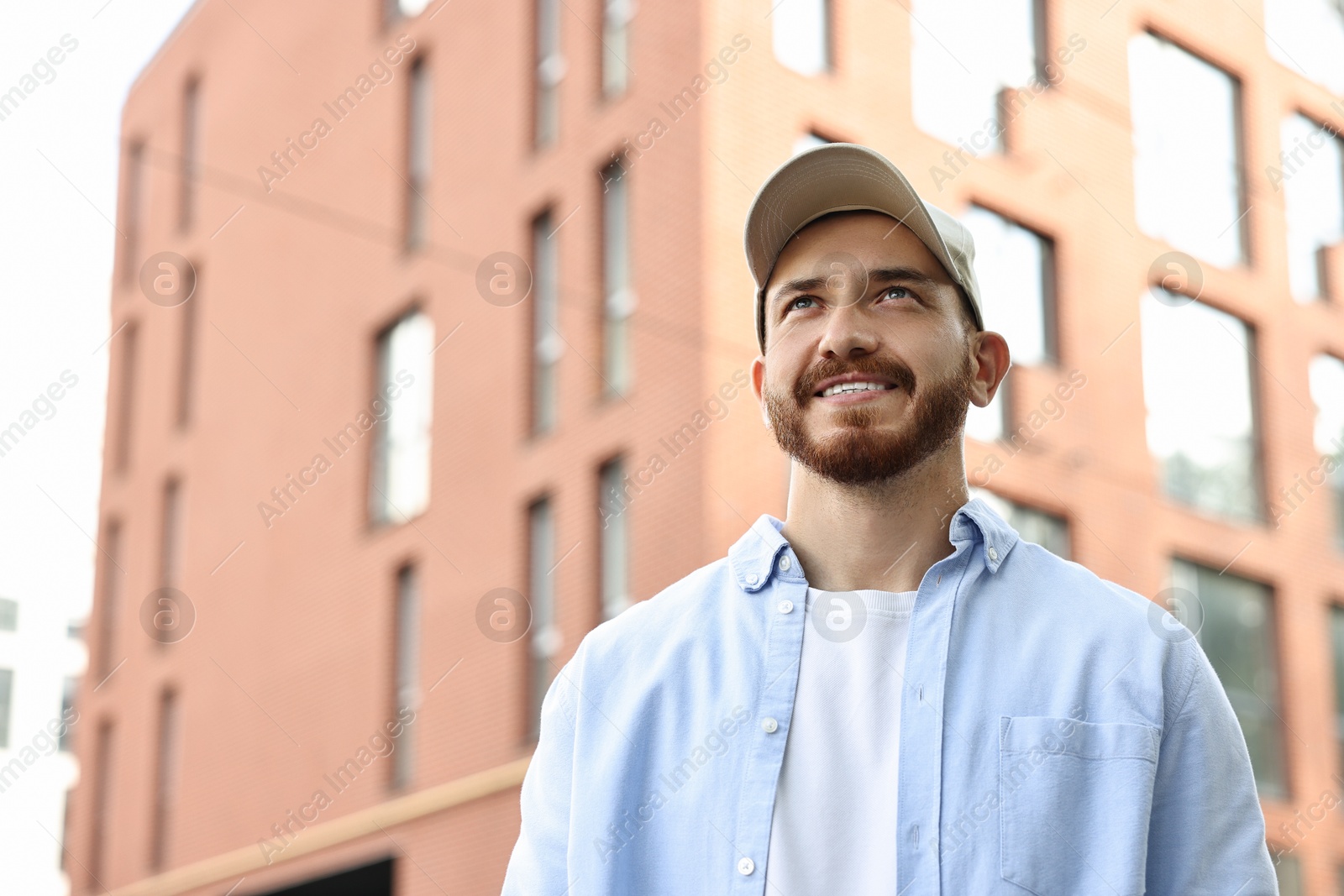 Photo of Portrait of smiling man in baseball cap outdoors. Space for text