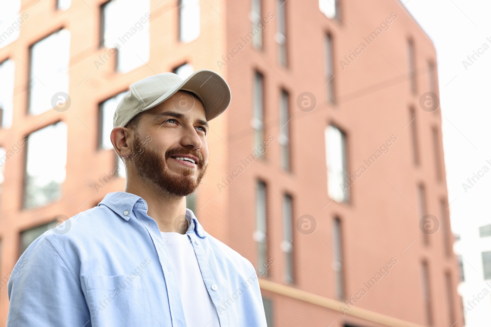 Photo of Portrait of smiling man in baseball cap outdoors. Space for text