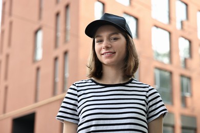 Portrait of smiling woman in baseball cap outdoors