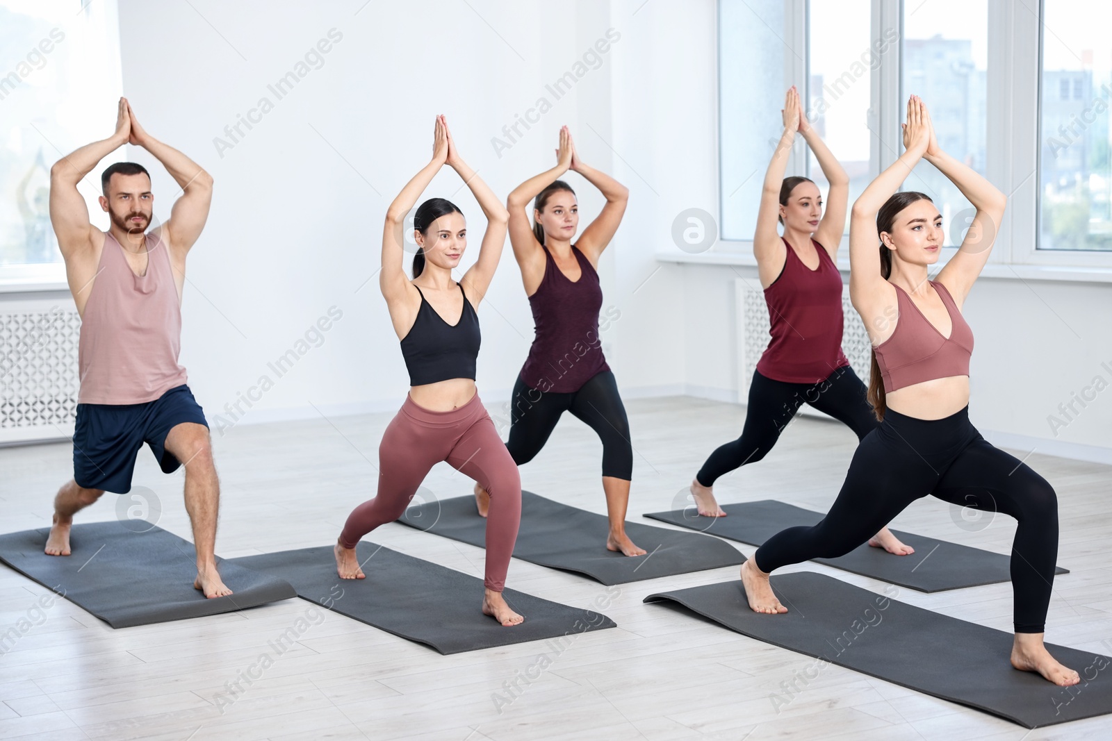 Photo of Group of people practicing yoga on mats in class