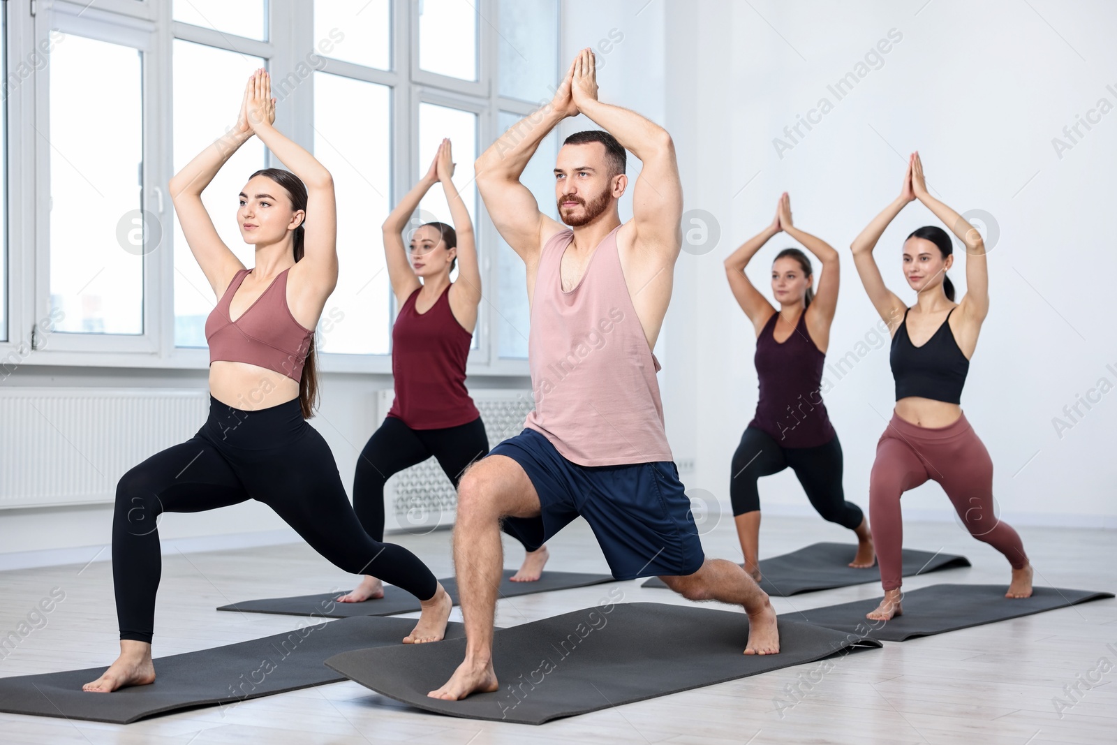 Photo of Group of people practicing yoga on mats in class