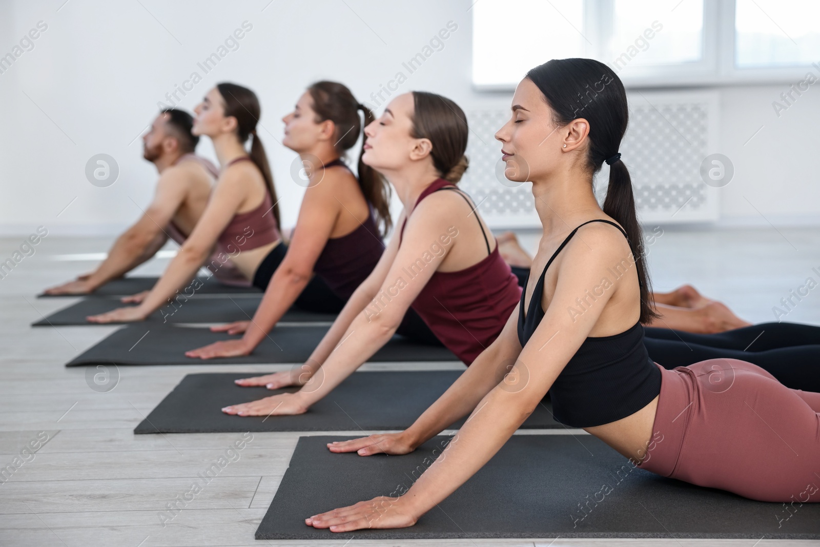 Photo of Group of people practicing yoga on mats in class