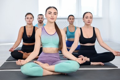 Group of people meditating on mats in yoga class