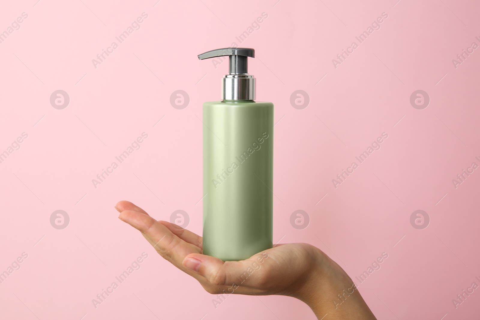 Photo of Woman with shampoo bottle on pink background, closeup