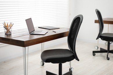 Photo of Black chair, laptop and desk in office