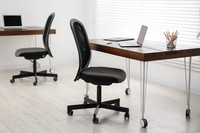 Photo of Black chair, laptop and desk in office