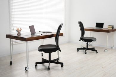 Photo of Black chair, laptop and desk in office