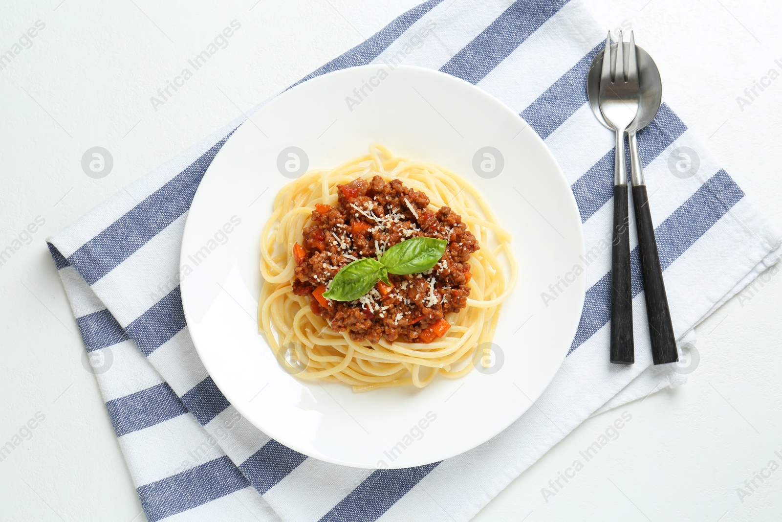 Photo of Delicious pasta bolognese and cutlery on white table, flat lay