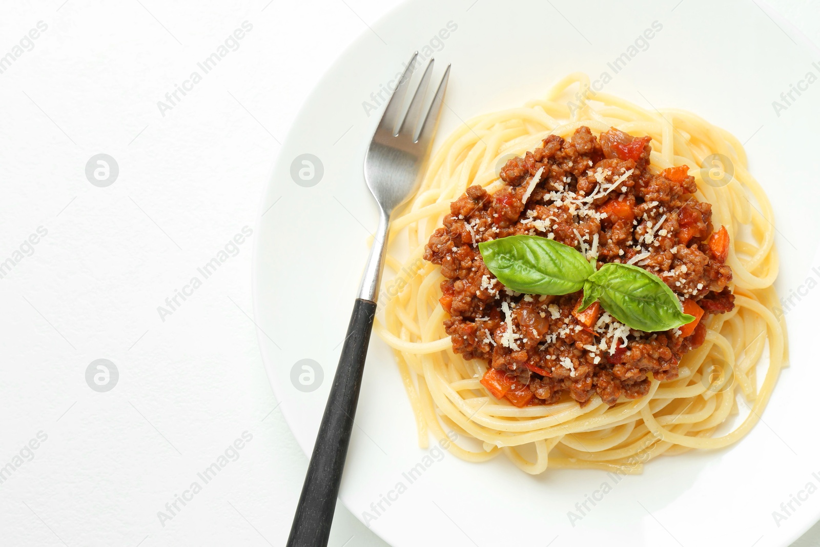 Photo of Tasty pasta bolognese on white table, top view. Space for text