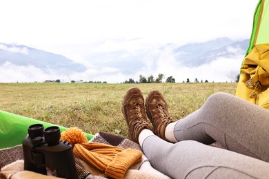 Woman wearing trekking shoes and lying in tent outdoors, closeup