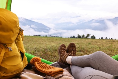 Woman wearing trekking shoes and lying in tent outdoors, closeup