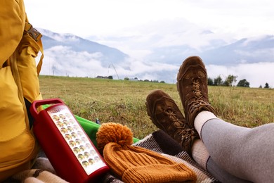 Photo of Woman wearing trekking shoes and lying in tent outdoors, closeup