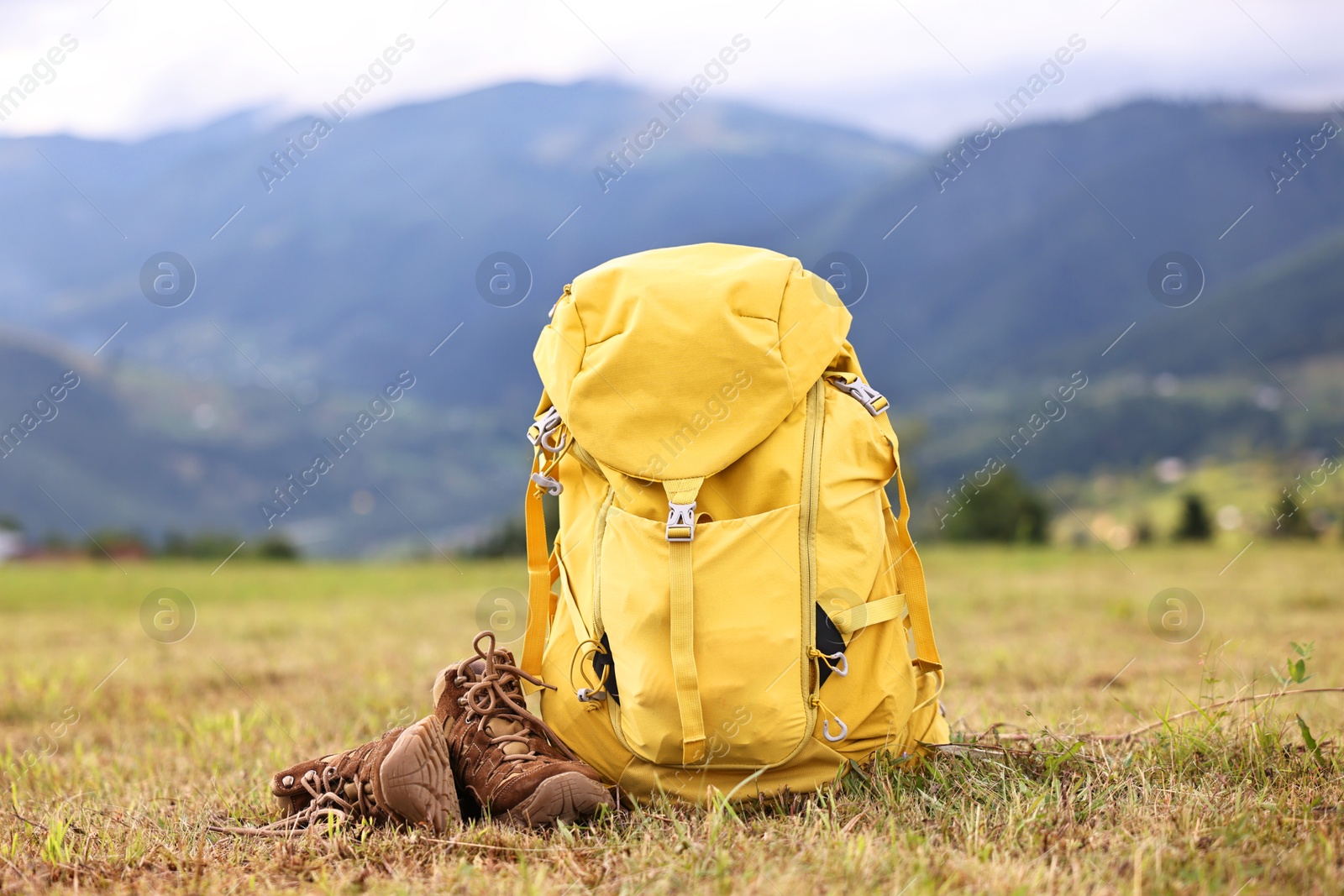 Photo of Backpack and trekking shoes on grass outdoors