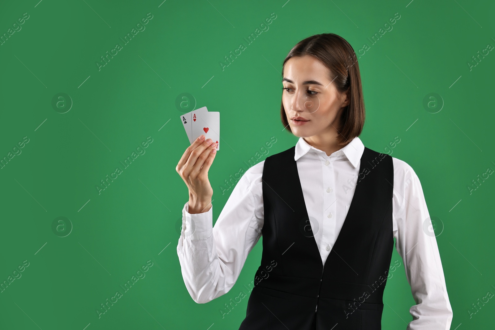 Photo of Croupier with playing cards on green background