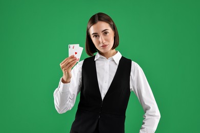 Croupier with playing cards on green background