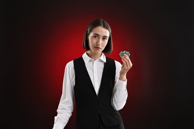 Photo of Croupier with casino chips on dark red background