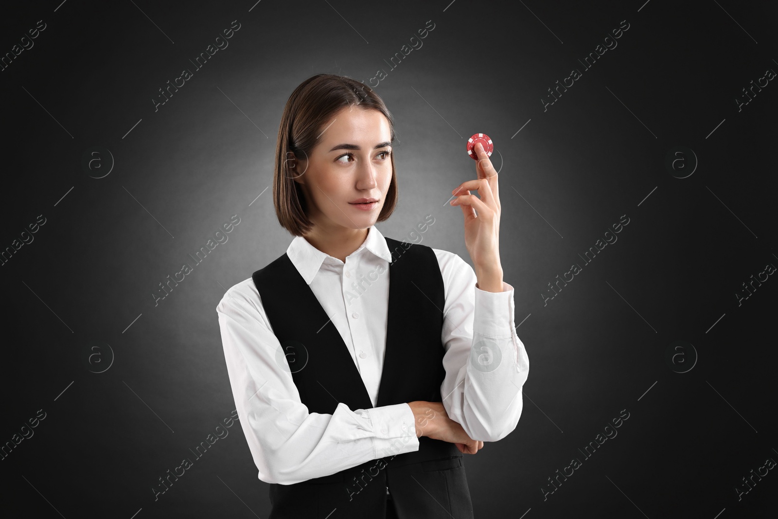 Photo of Croupier with casino chip on black background