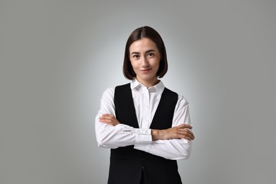 Portrait of professional croupier on grey background