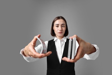 Photo of Professional croupier shuffling cards on grey background