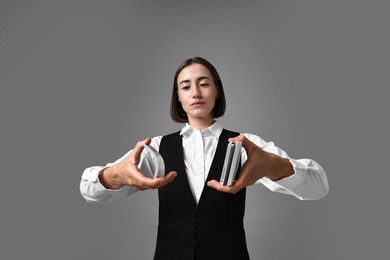 Photo of Professional croupier shuffling cards on grey background