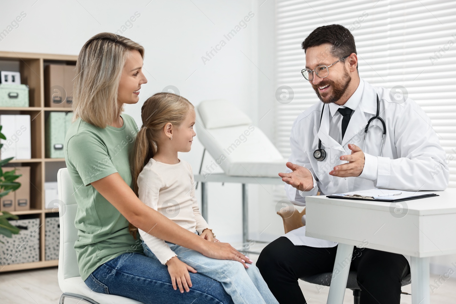 Photo of Doctor consulting little girl and her mother in hospital