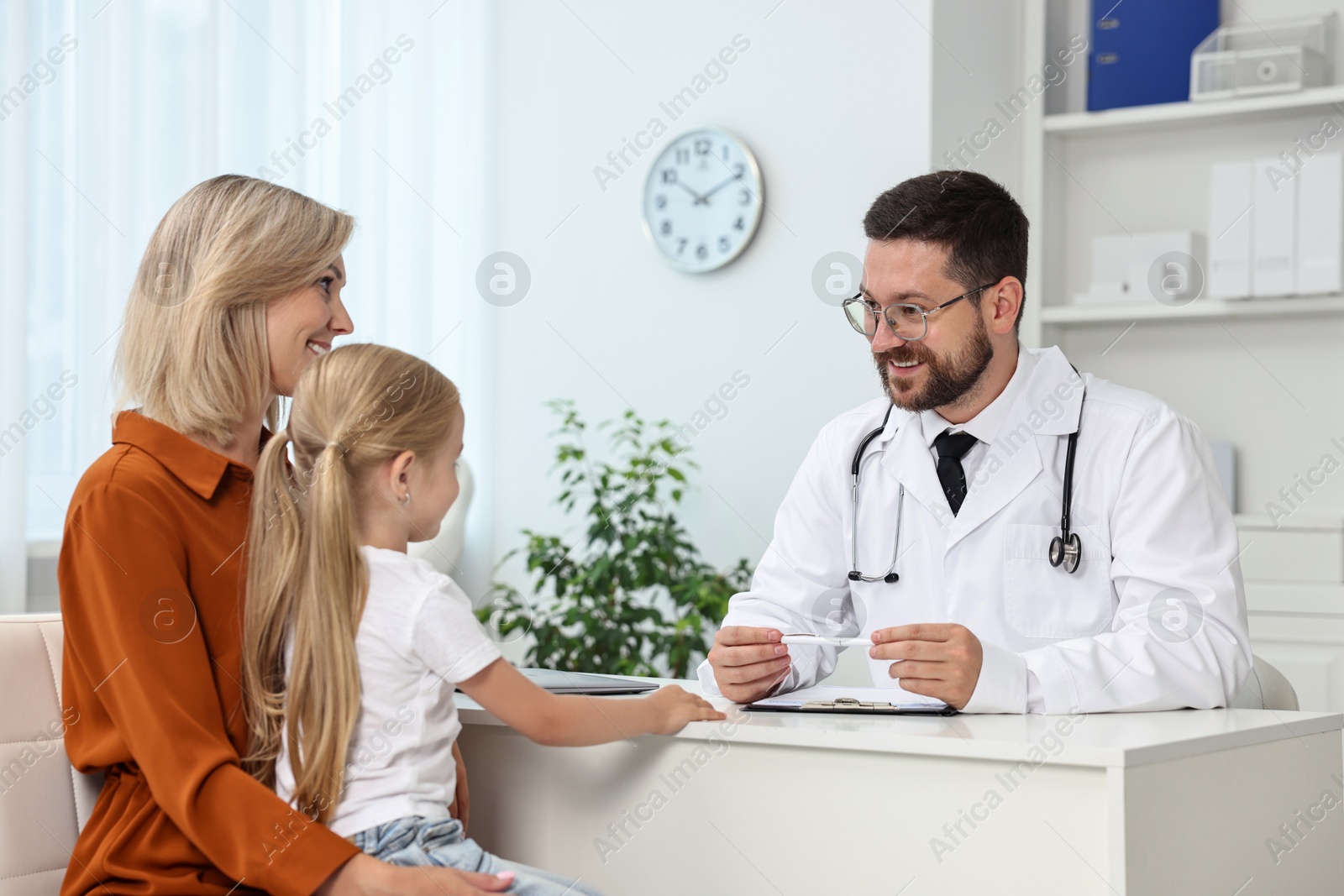 Photo of Doctor consulting little girl and her mother in hospital