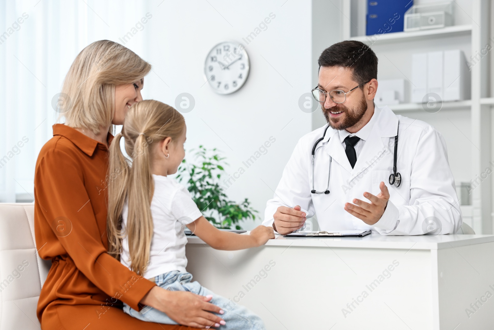 Photo of Doctor consulting little girl and her mother in hospital