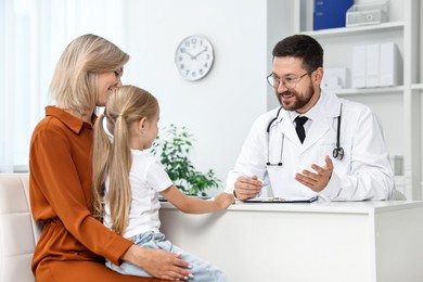 Doctor consulting little girl and her mother in hospital