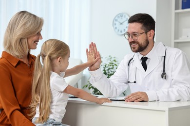 Photo of Mother and her little daughter having appointment with doctor in hospital