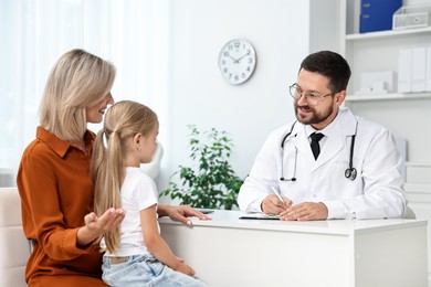 Photo of Doctor consulting little girl and her mother in hospital