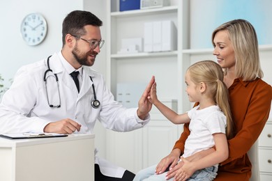 Mother and her little daughter having appointment with doctor in hospital