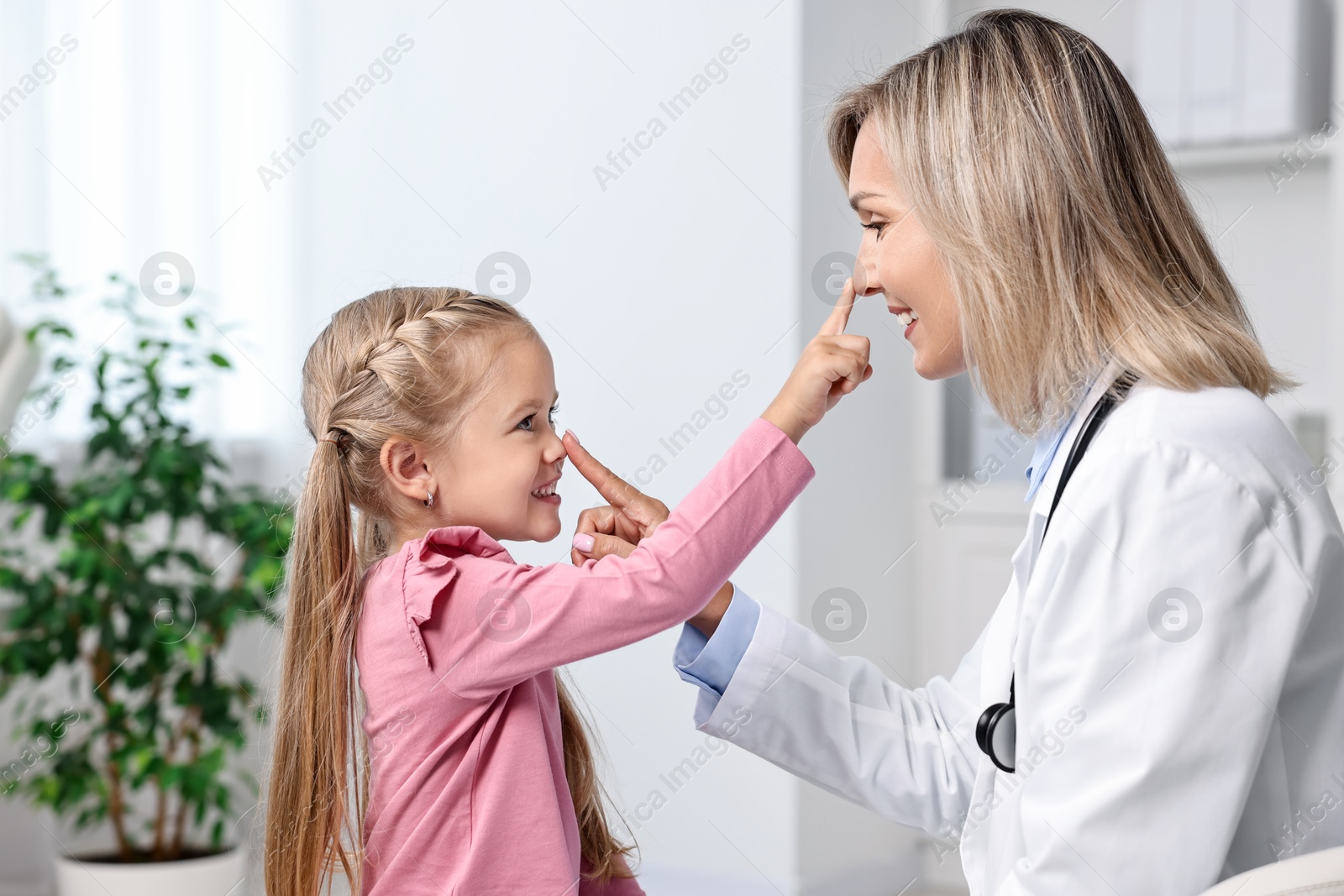 Photo of Little girl having fun with doctor in hospital