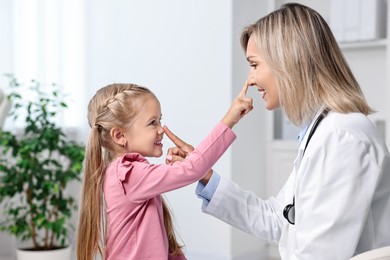 Photo of Little girl having fun with doctor in hospital