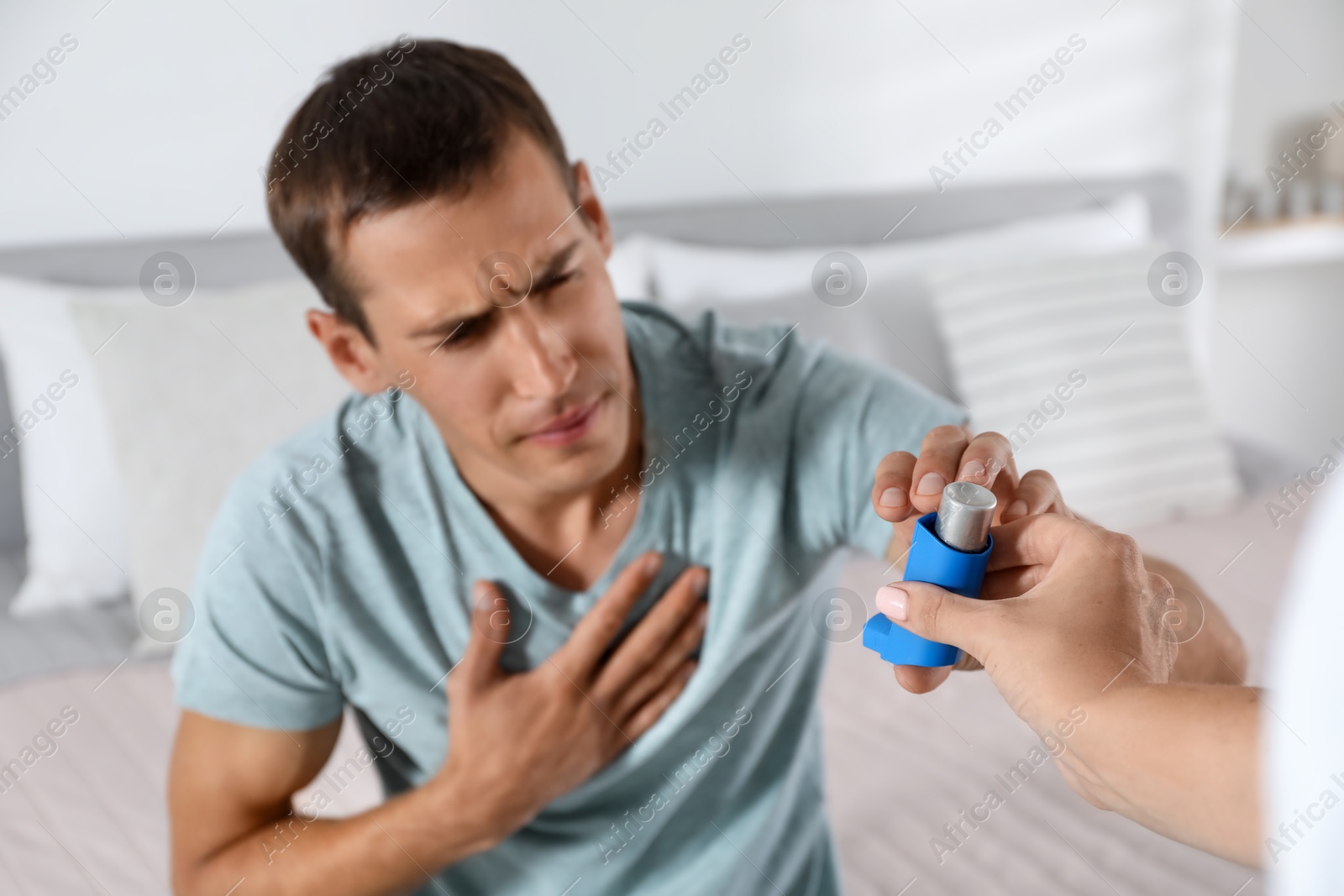 Photo of Man getting asthma inhaler at home, selective focus