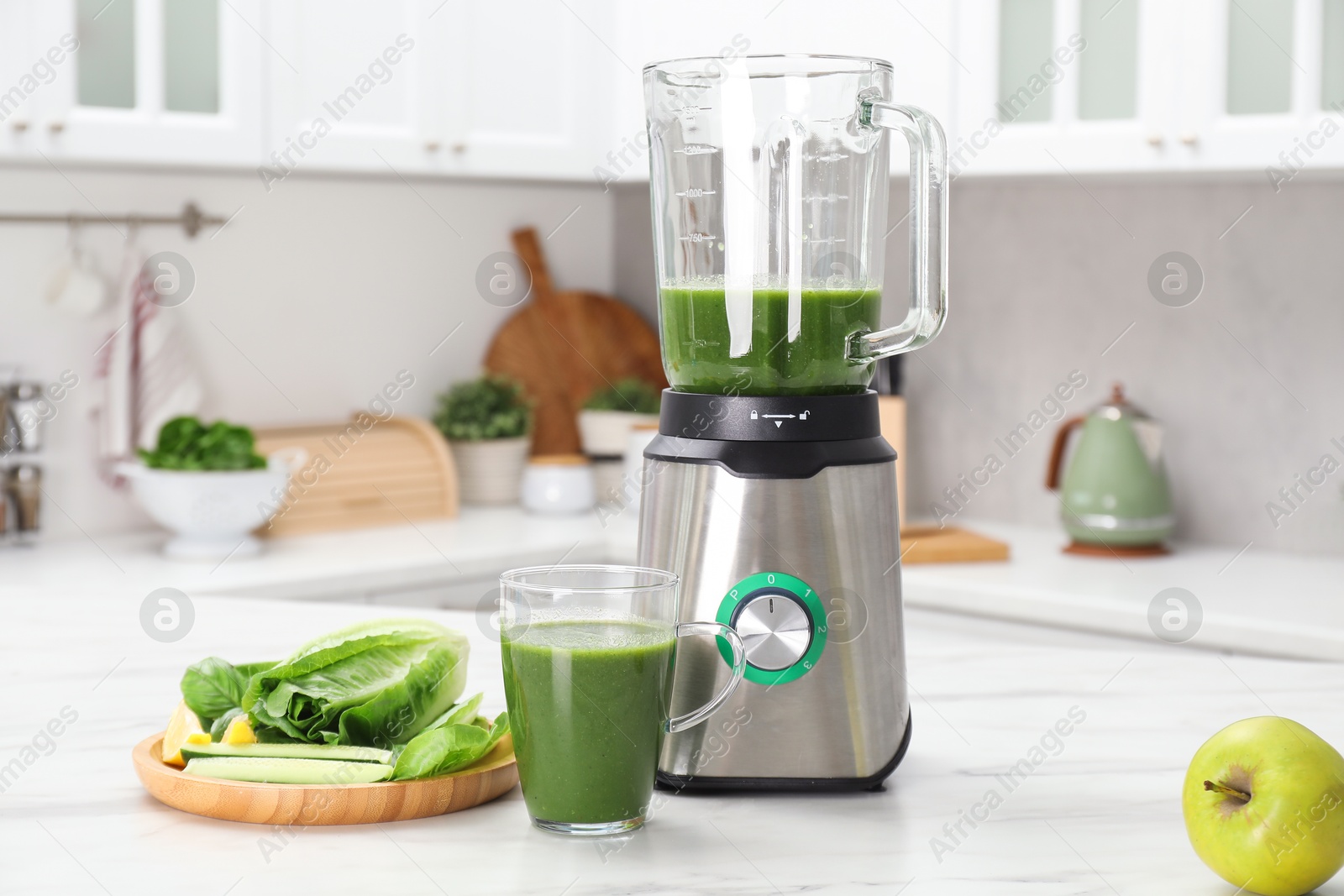 Photo of Delicious smoothie, modern blender and ingredients on white marble table in kitchen