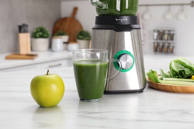 Photo of Modern blender with smoothie and ingredients on white marble table in kitchen