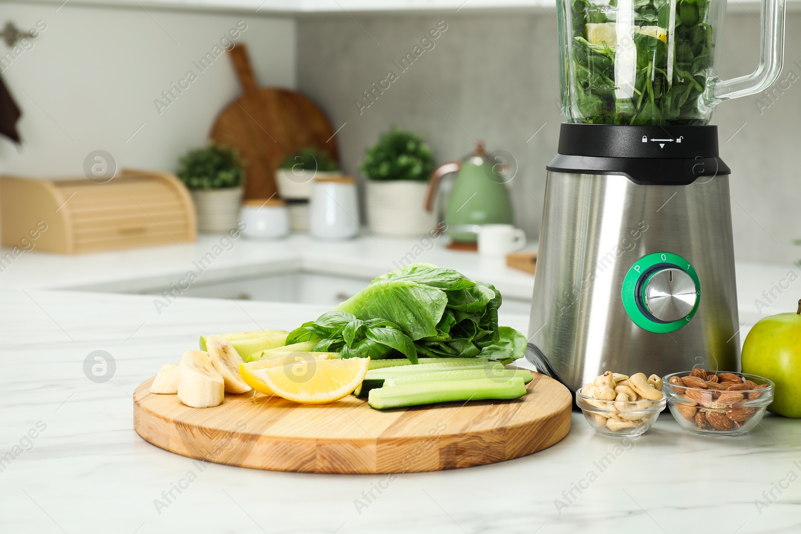 Photo of Modern blender with smoothie and ingredients on white marble table in kitchen. Space for text