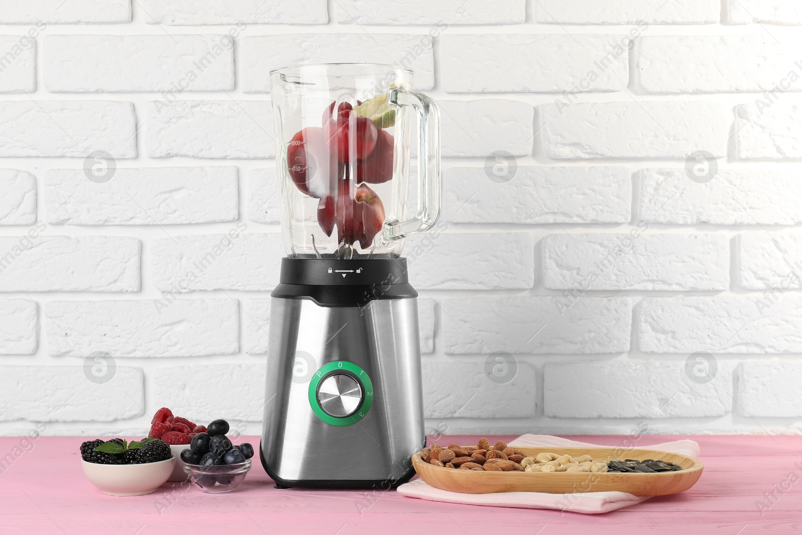 Photo of Blender and fresh ingredients on pink wooden table