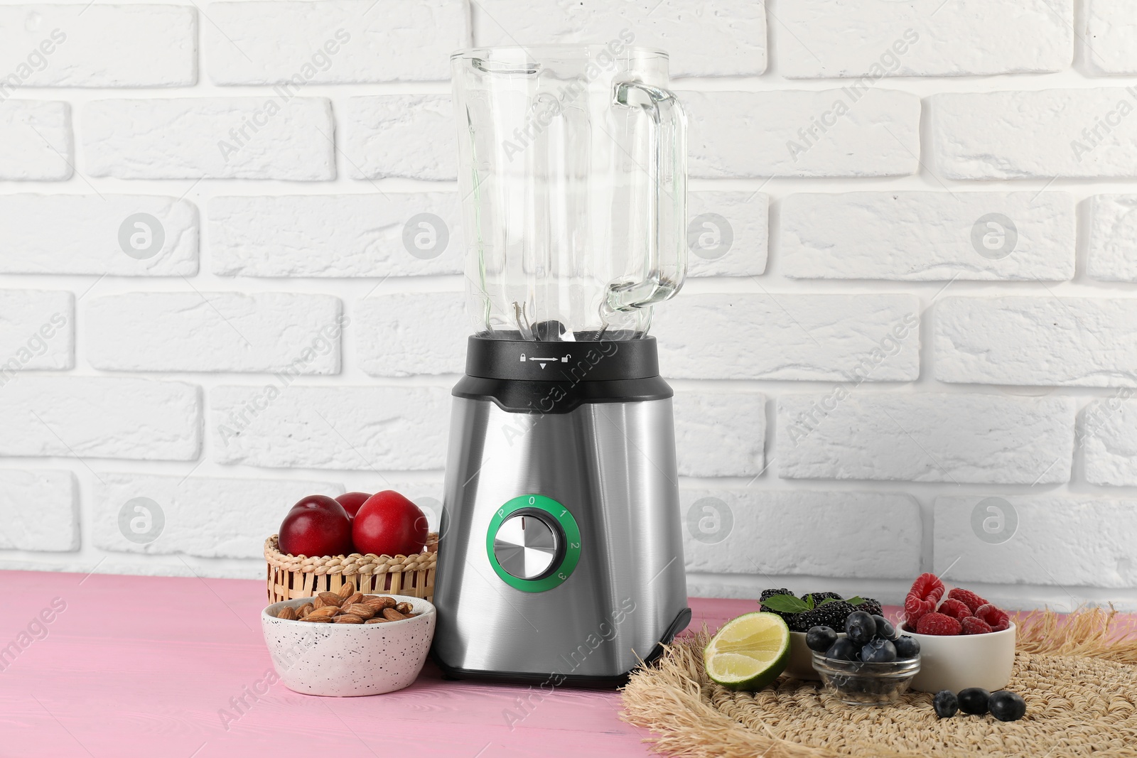 Photo of Blender and fresh ingredients on pink wooden table