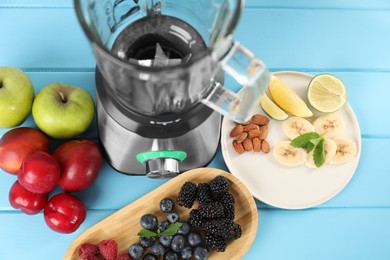 Photo of Blender and fresh ingredients on light blue wooden table, above view