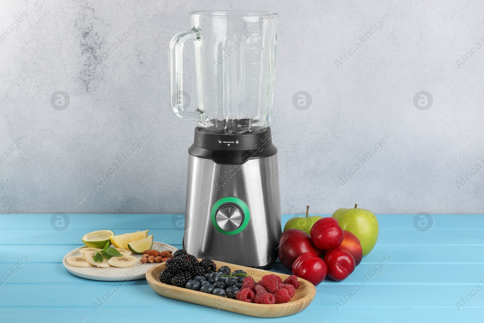 Photo of Blender and fresh ingredients on light blue wooden table