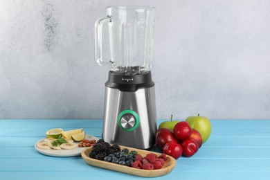 Blender and fresh ingredients on light blue wooden table