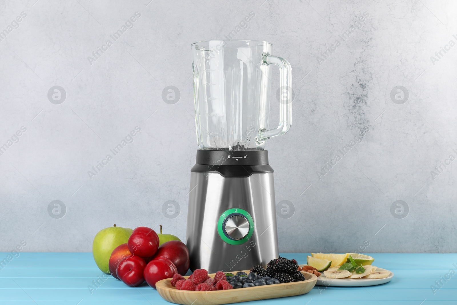 Photo of Blender and fresh ingredients on light blue wooden table