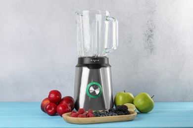 Photo of Blender and fresh ingredients on light blue wooden table