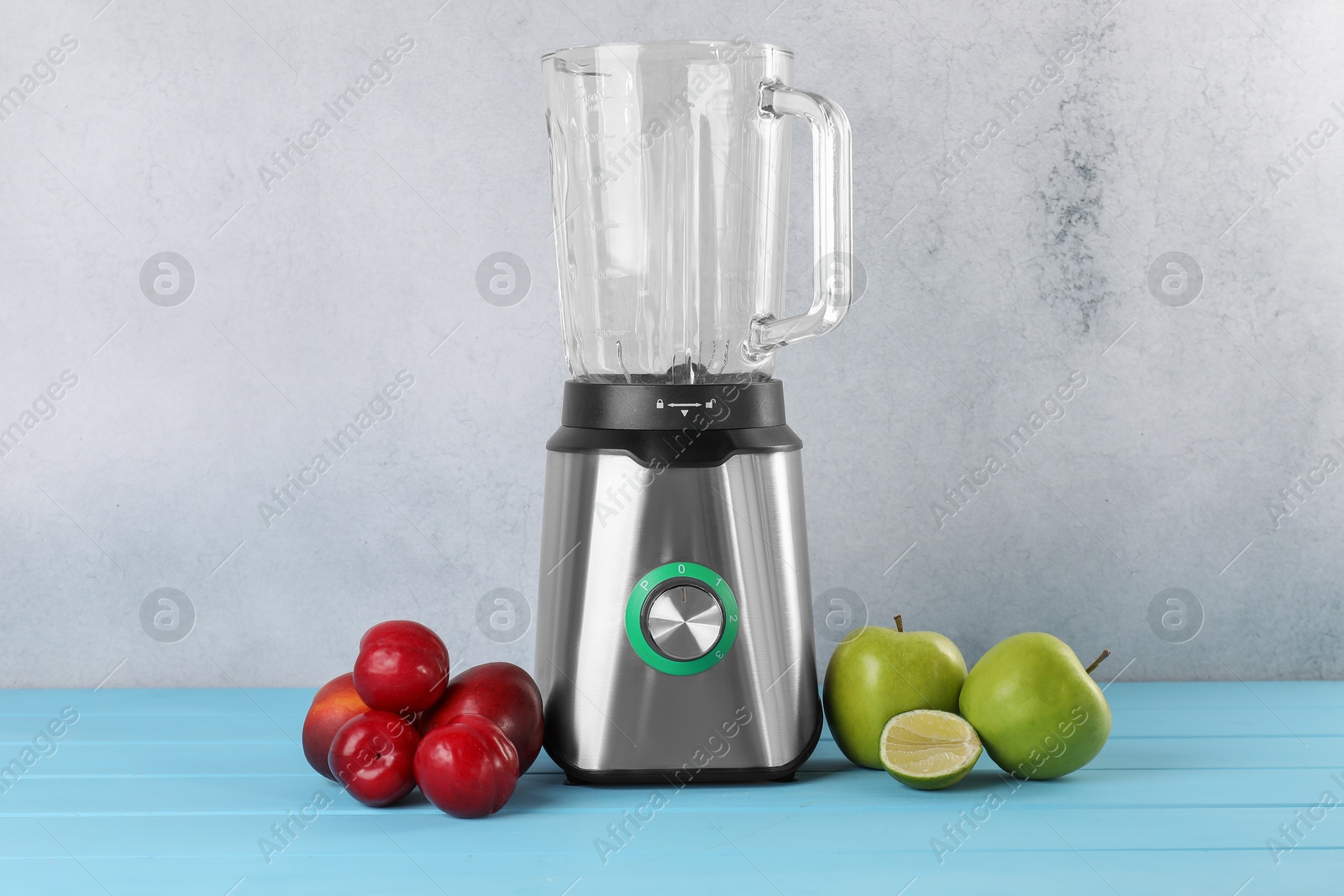 Photo of Blender and fresh ingredients on light blue wooden table